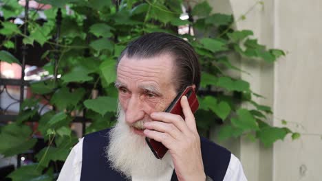 an older man with a white beard is on the phone