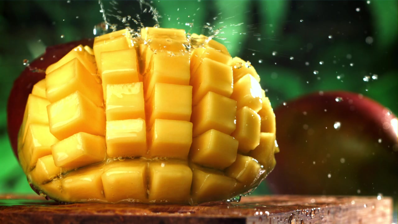 Acqua che schizza su cubetti di mango appena tagliati al rallentatore