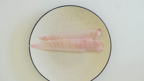 Chef-placing-freshly-trimmed-fillets-on-plate