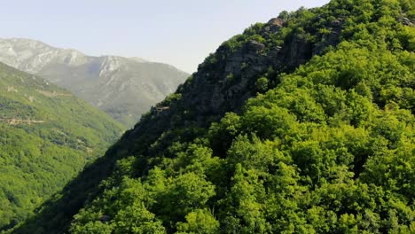 Fly-close-to-mountain-green-trees