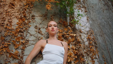 chica de lujo posando la naturaleza apoyándose en la vieja pared. magnífica cámara de búsqueda de modelo