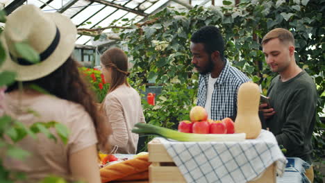 friends shopping for produce at a greenhouse farmers market
