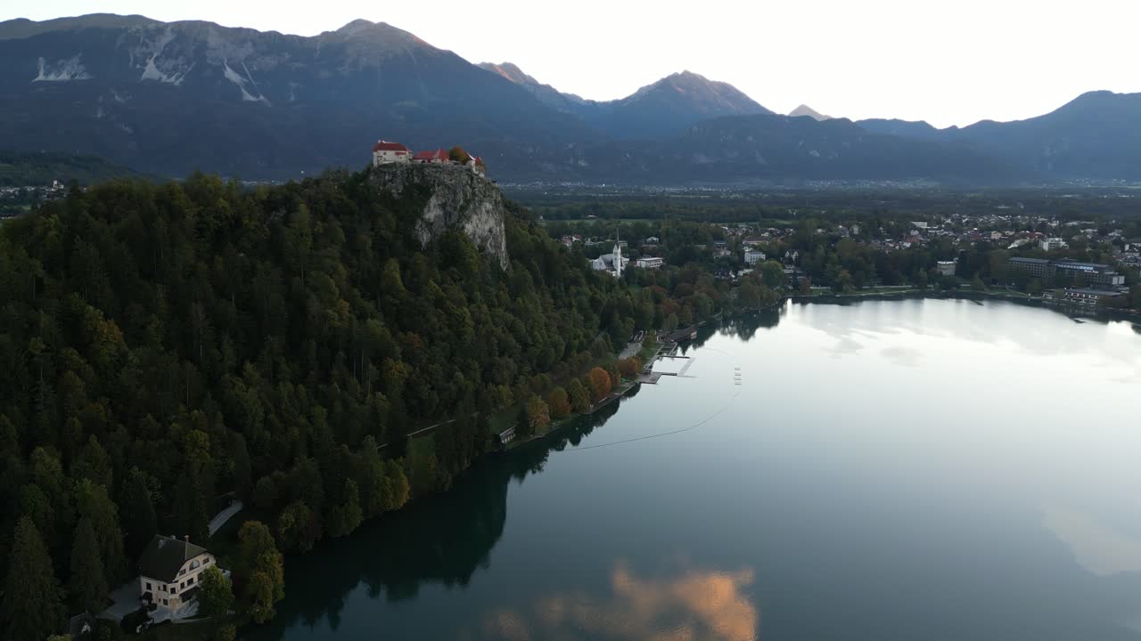 emergiendo a través de las nubes en el lago bled en eslovenia durante el otoño al amanecer