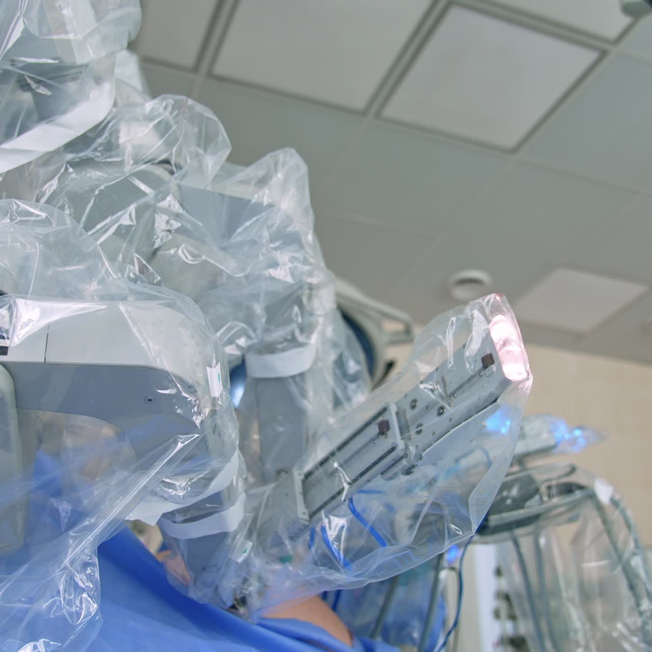 Advanced technological equipment for minimal invasive surgery. Da Vinci robot covered with plastic for keeping sterility. Low angle view