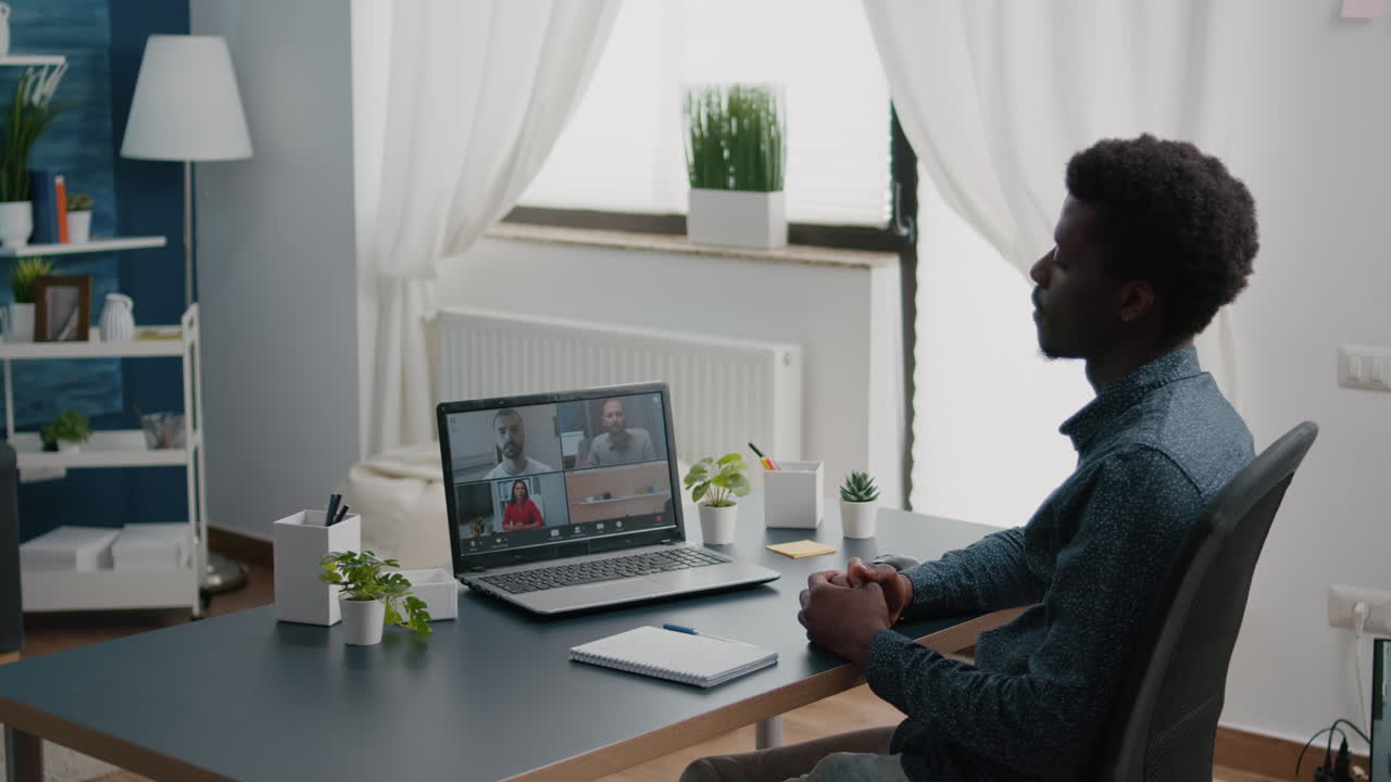 Black man remote worker working from home taking online office call