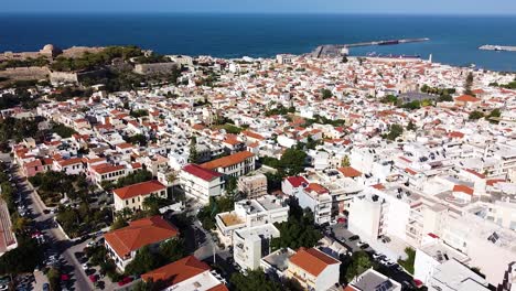 Downtown-buildings-and-narrow-streets-of-Rethymno-town,-aerial-drone-view