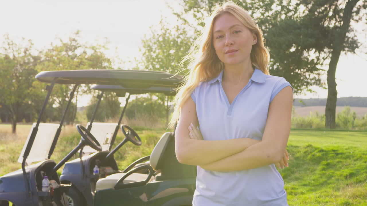 Ritratto di golfista donna in piedi accanto al cart sul campo da golf.