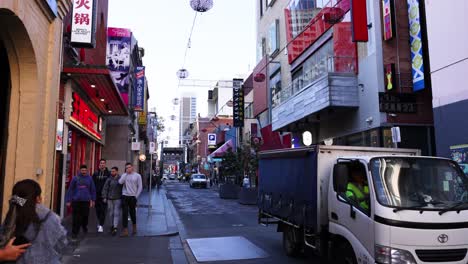 pedestrians and truck in bustling chinatown street