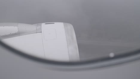 airplane engine seen through a window during a cloudy flight at high altitude