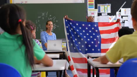 Vorderansicht-Eines-Afroamerikanischen-Schuljungen,-Der-Im-Klassenzimmer-Die-Amerikanische-Flagge-Erklärt-4k