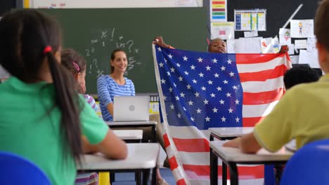 front view of african american schoolboy explaining about american flag in the classroom 4k