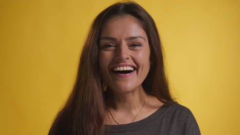 studio portrait of excited woman celebrating good news winning money against yellow background 2