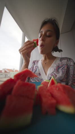 woman eating sliced watermelon