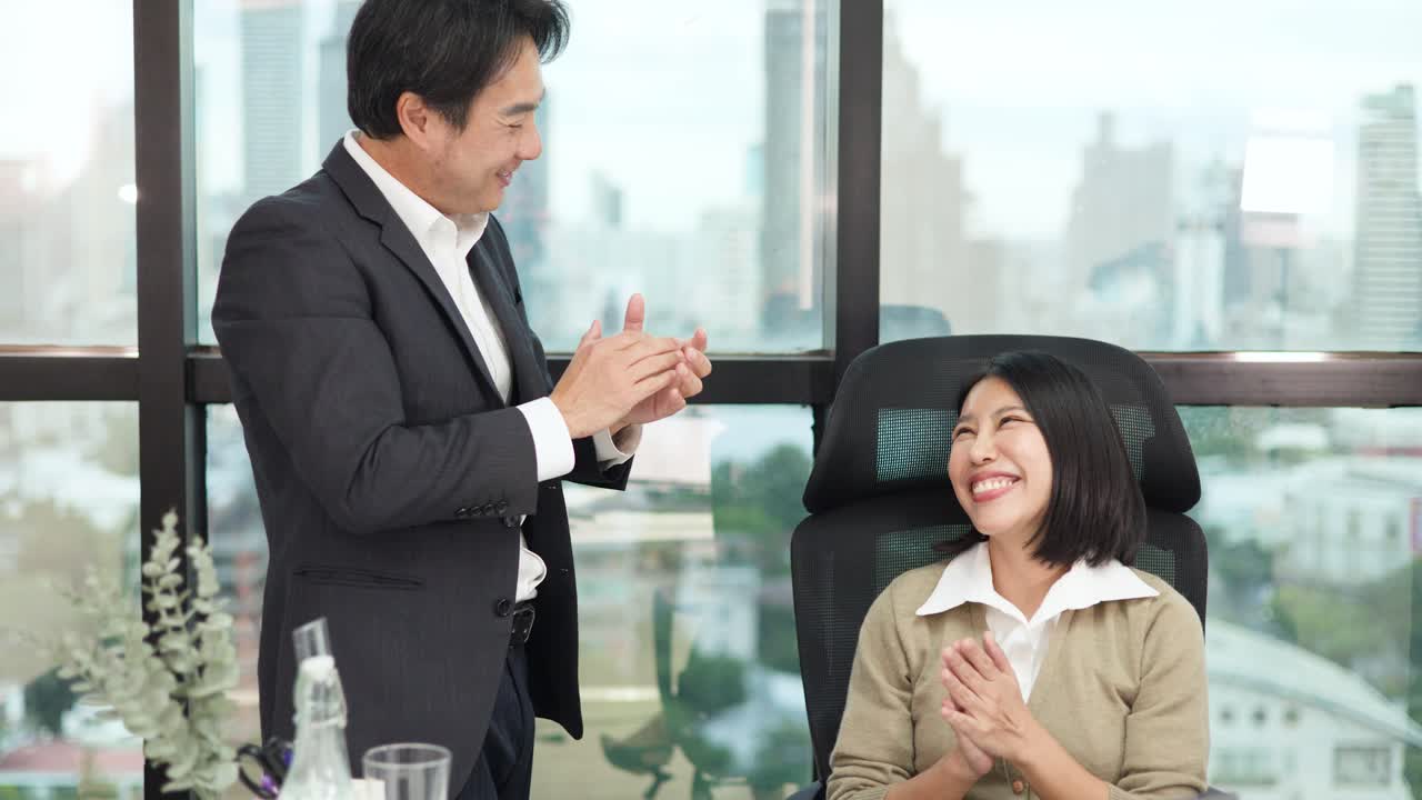 มืออาชีพสองคนยิ้มและจับมือกันในส านักงานที่ทันสมัยและสว่างสดใสพร้อมวิวเมือง