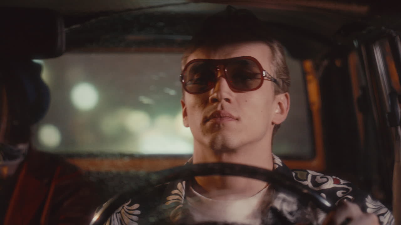 Man in Sunglasses Driving Retro Taxi Cab on Rainy Night