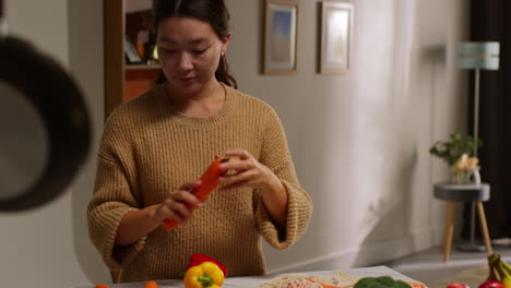 woman getting home from food shopping unpacking and preparing bag of fresh vegetables onto counter in kitchen