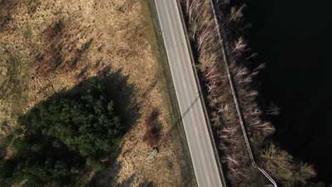 Toma-De-Arriba-Hacia-Abajo-Con-Drones-Del-Paisaje-Del-Lago-Otoñal-Y-La-Carretera-Que-Pasa-Por-El-Gasoducto-Con-Autos-Que-Pasan