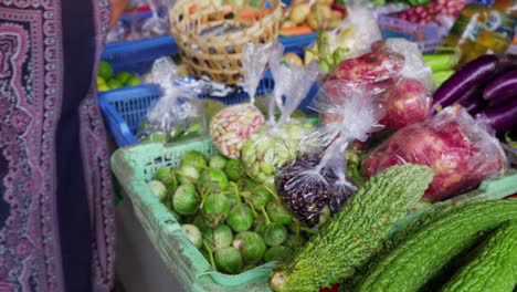 Una-Mujer-Selecciona-Verduras-Frescas-En-Un-Vibrante-Mercado-De-Bali.