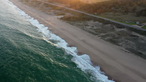 Toma-Escénica-Inclinada-Hacia-Arriba-Puesta-De-Sol-Olas-Playa-Punta-Del-Este-Uruguay,-Campaña-Costera-Carretera-Neblina