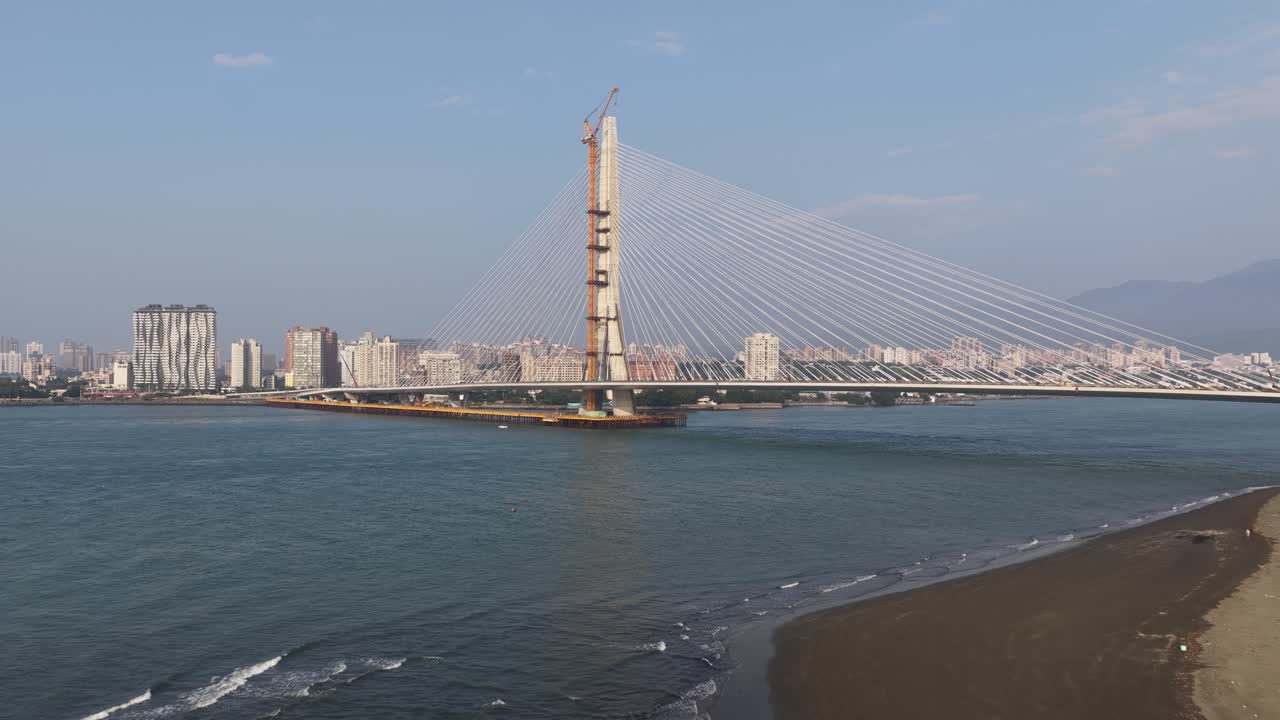 Marea crescente che nasconde la costa sabbiosa vicino a un ponte moderno