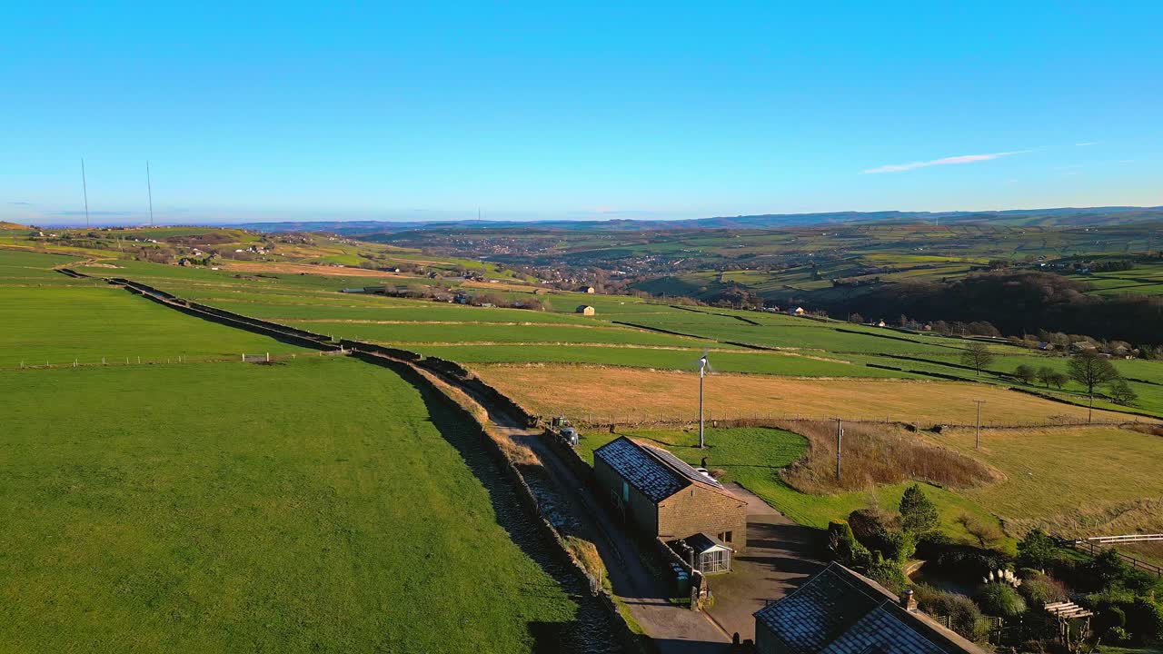 Aerial drone video footage of English farmland showing green fields, patchwork landscape, hills and a farmhouse in a rural setting