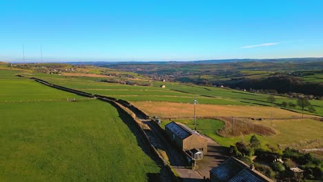 Drohnen-Videomaterial-Aus-Der-Luft-Von-Englischem-Ackerland-Mit-Grünen-Feldern,-Patchwork-Landschaften,-Hügeln-Und-Einem-Bauernhaus-In-Ländlicher-Umgebung