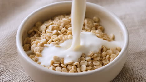 milk being poured into a bowl of cereal