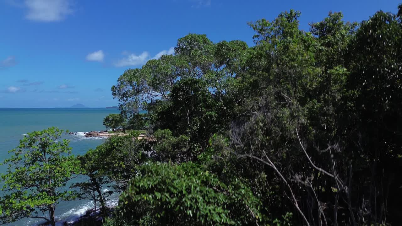Aerial drone view rising above dense green jungle to reveal remote secluded beaches on Koh Lanta Thailand, featuring crystal clear water, tropical coastline and pristine travel destination paradise