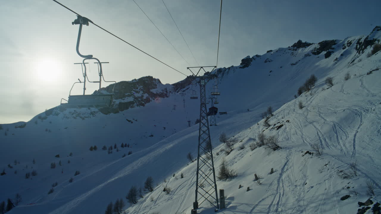 Panorami suggestivi dalla seggiovia sopra Anzère con cieli leggermente coperti e un sole tenue che filtra sulle Alpi svizzere e la Valle del Rodano. Atmosfera alpina intensa, paesaggio invernale, sensazione da località turistica cinematografica.