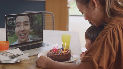 Asiatische-Familie-Feiert-Zu-Hause-Geburtstag,-Während-Der-Vater-Per-Videoanruf-Arbeitet