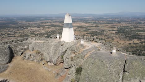 woman on megalithic fortification of monsanto castle greets drone, portugal