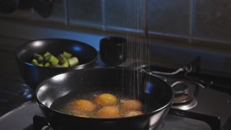 Sprinkling-Salt-On-Raw-Eggs-In-A-Bowl