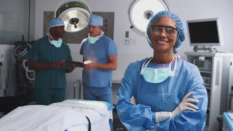 portrait of female surgeon wearing scrubs and protective glasses in hospital operating theater