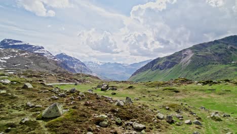 Aerial-Flying-Over-Rocky-Green-Landscape-To-Reveal-Julier-Pass-With-Epic-Valley-Views-In-Distance