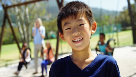 portrait of happy schoolboy standing in playground