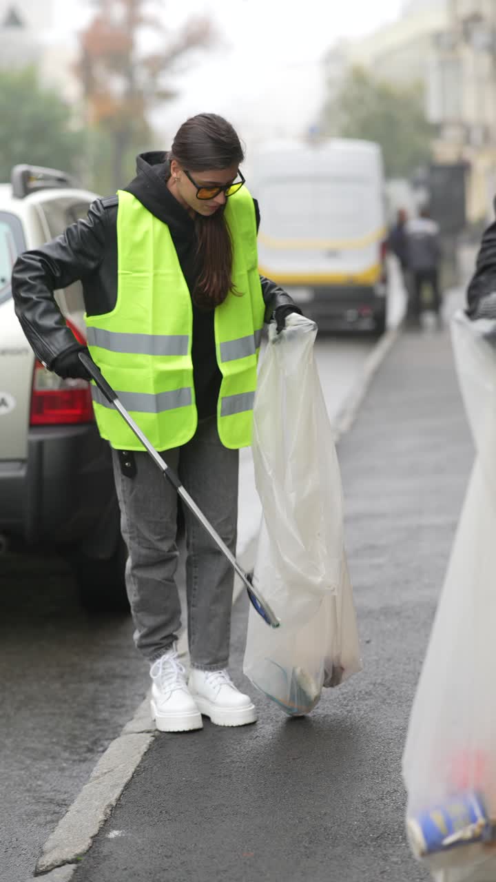 mujer limpiando la basura en la calle