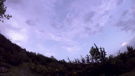 해가 뜨는 동안 산에서 구름이 인 하늘의 타임스