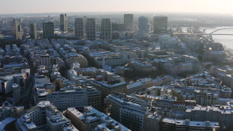 wide panorama aerial shot of bratislava on sunny winter morning covered in snow, high rise buildings in background