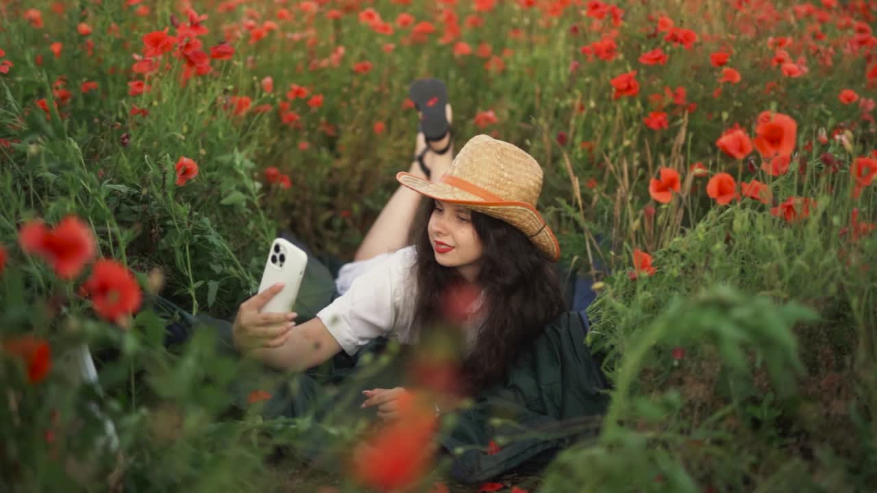 Woman taking a selfie in a beautiful poppy field
