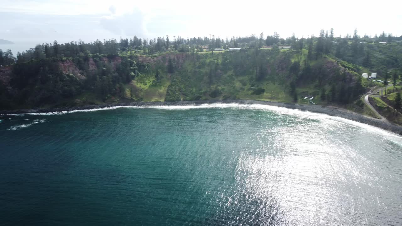 vista aérea del pintoresco paisaje de la isla de norfolk con una vista del agua turquesa del mar con olas espumosas que se rompen en los acantilados rocosos y la vegetación de bosques y arbustos