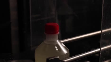 cerrar botellas de vinagre que se mueven a lo largo de una cinta transportadora automática en una fábrica de procesamiento de vinagre