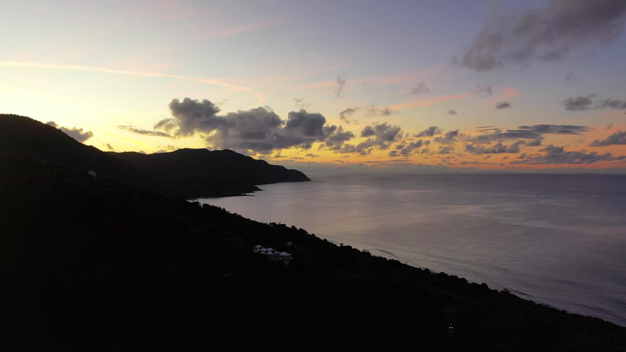Early morning light paints the Caribbean Sea near St. Croix, where a scenic peninsula glows beneath vibrant clouds and tranquil water, creating a serene tropical landscape