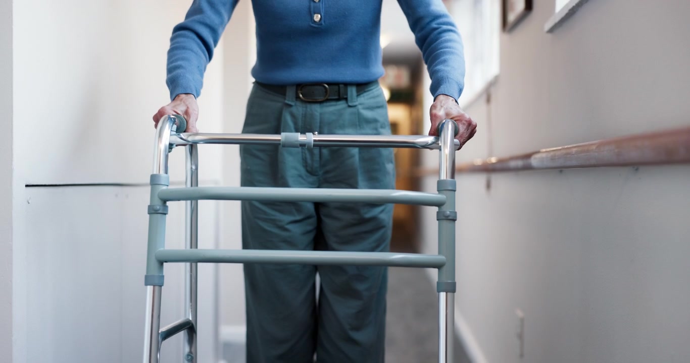 Senior Person Walking Down Hallway Using a Mobility Walker
