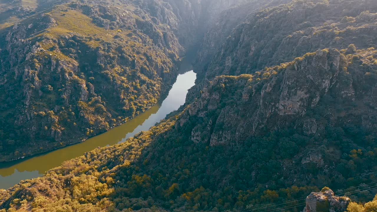 Un video drone cattura viste mozzafiato di paesaggi montuosi con un fiume che scorre attraverso il cuore della natura