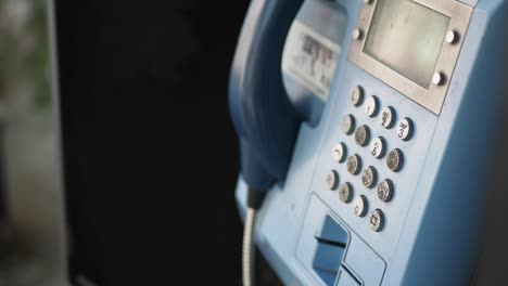 closeup of a vintage blue payphone