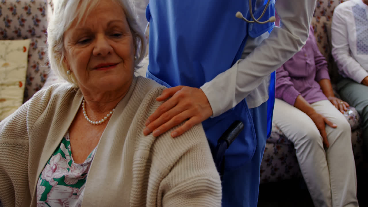 Vista frontale di donna anziana attiva che tiene la mano di una dottoressa in una casa di riposo 4k