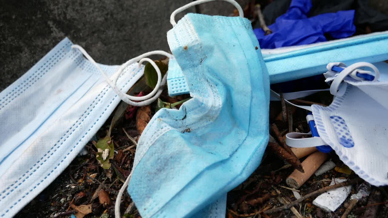 더러운 일회용 코로나 바이러스 얼굴 마스크와 거리 연석 근접 촬영에 담배 쓰레기 중 라텍스 장갑