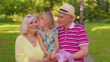 Nieta-Pequeña-Y-Linda-Abrazando-A-Su-Abuela-Y-A-Su-Abuelo,-Pareja-Familiar-En-El-Parque