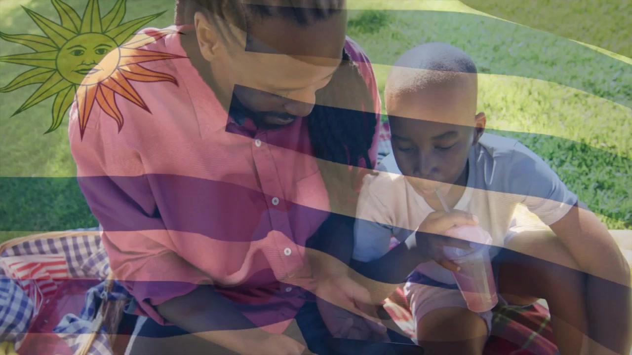 Father and son taking smartphone selfie then exploring animated tablet technology content in park