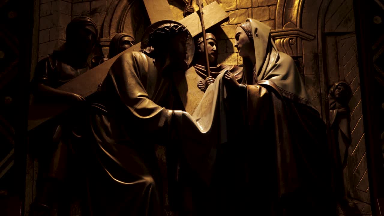 다른 성서 인물 들 에 둘러싸여 십자가 를 들고 있는 예수 의 조각, 4k 해상도 로 촬영